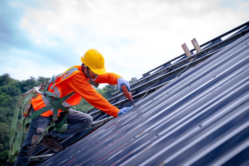 Roofer worker installing asphalt shingle on top of the new roof